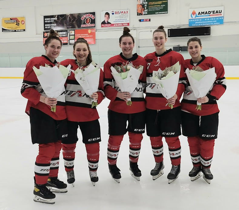 Les cinq hockeyeuses finissantes des Titans sur la glace, tenant un bouquet de fleurs